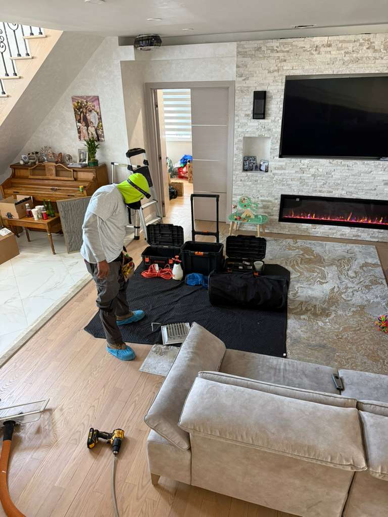 Duct cleaning equipment setup in residential living room, Nassau County home service